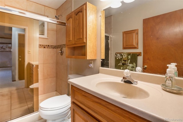 bathroom featuring tiled shower, vanity, and toilet