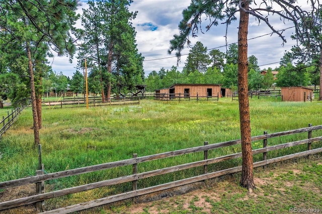 view of yard featuring an outdoor structure and a rural view