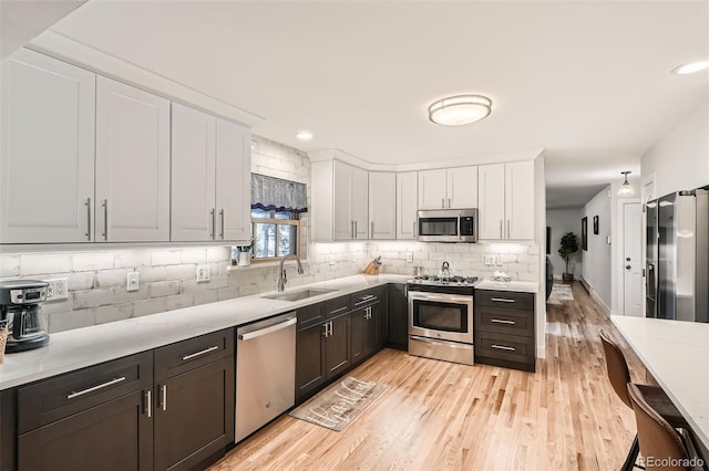 kitchen featuring sink, tasteful backsplash, white cabinetry, and stainless steel appliances