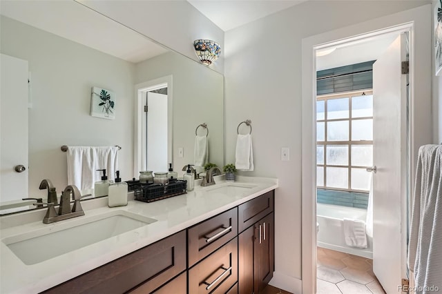 bathroom with a washtub, vanity, and tile patterned flooring