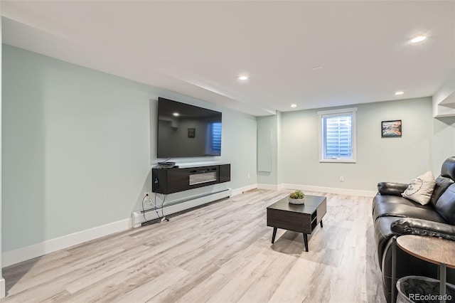 living room with baseboard heating and light wood-type flooring