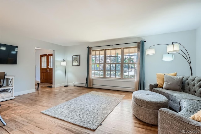 living room featuring wood-type flooring and a baseboard heating unit