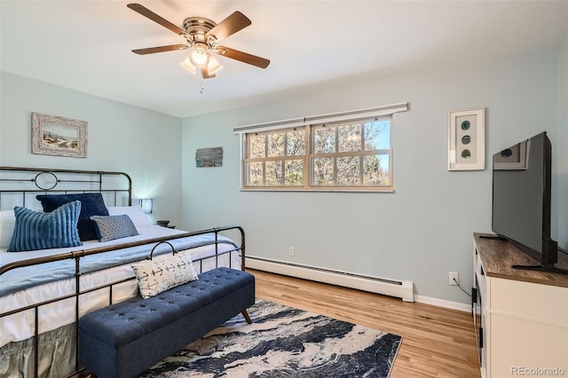 bedroom with a baseboard heating unit, light wood-style floors, baseboards, and ceiling fan