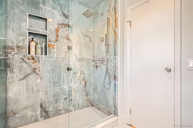 bathroom featuring a marble finish shower