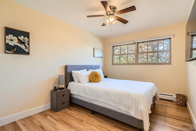 bedroom with light wood-style floors, baseboards, a baseboard heating unit, and a ceiling fan