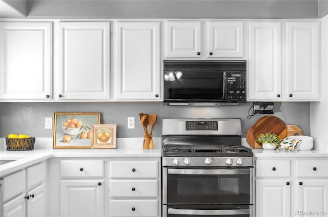 kitchen with light countertops, white cabinetry, stainless steel gas range oven, and black microwave