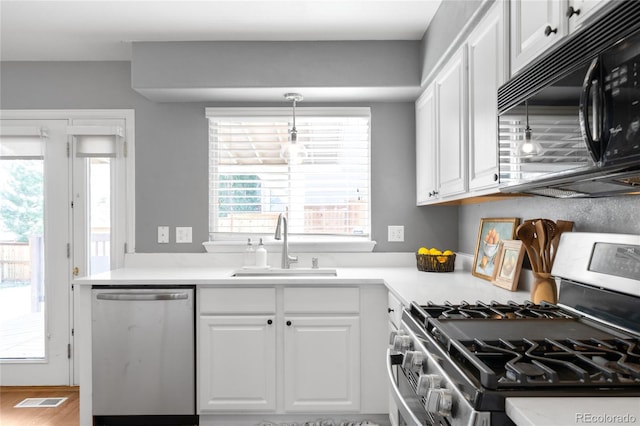 kitchen featuring white cabinets, appliances with stainless steel finishes, a sink, and visible vents