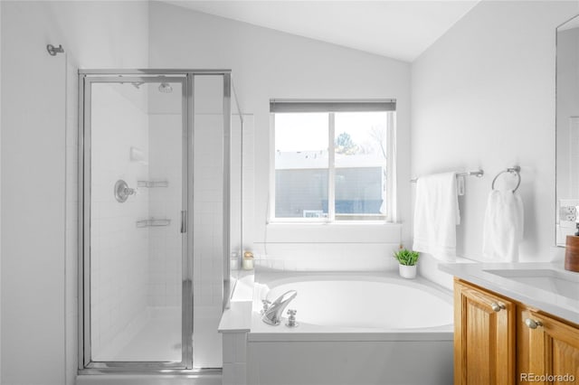 full bathroom with a shower stall, a garden tub, vanity, and lofted ceiling