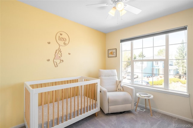 carpeted bedroom with baseboards, multiple windows, visible vents, and a nursery area