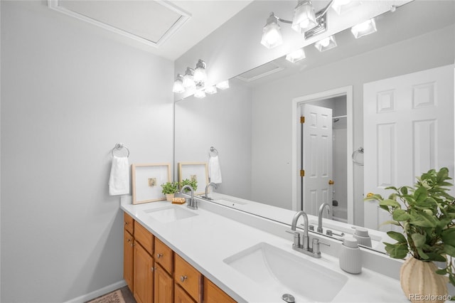 bathroom featuring double vanity, baseboards, and a sink