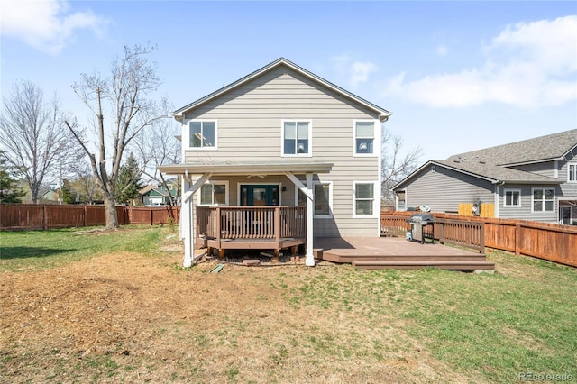 rear view of property with a yard, a deck, and a fenced backyard