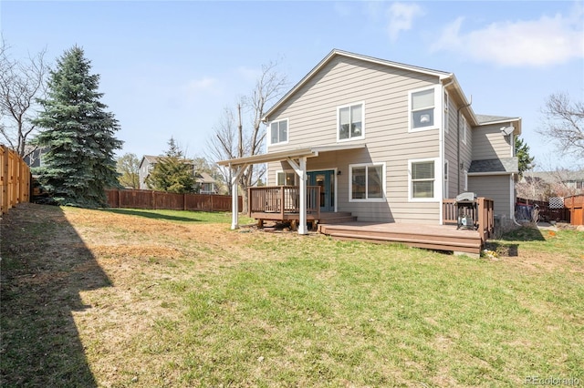 back of house featuring a yard, a fenced backyard, and a deck