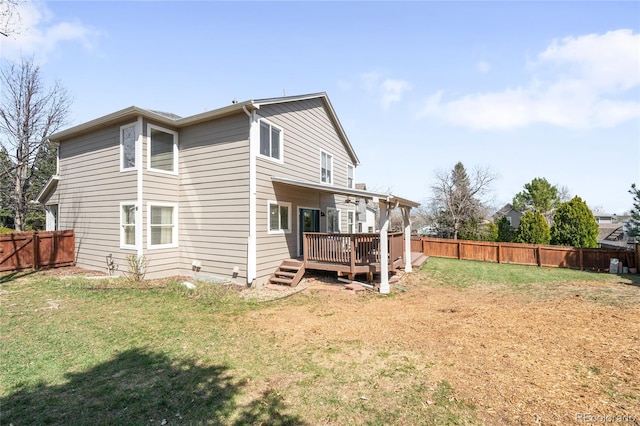 rear view of property with a yard, a fenced backyard, and a deck