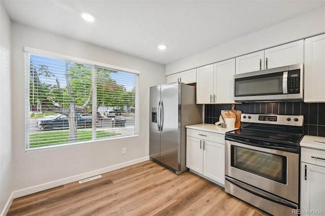 kitchen with white cabinets, stainless steel appliances, and a healthy amount of sunlight