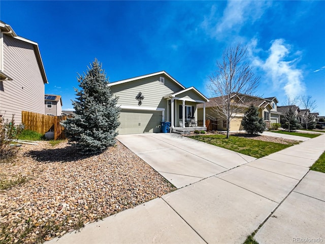 ranch-style house featuring an attached garage, driveway, fence, and a residential view