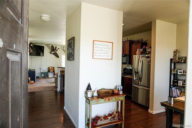 corridor featuring dark wood-type flooring and baseboards