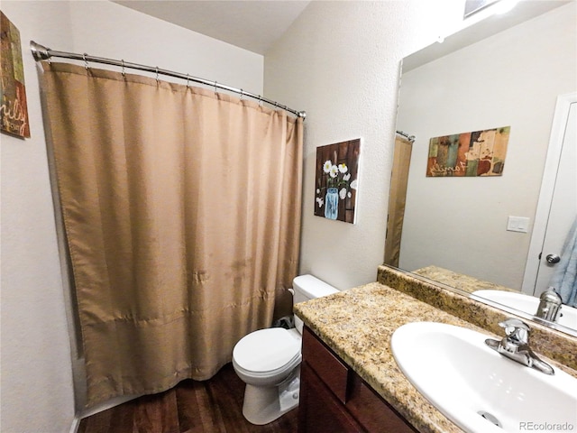 full bath featuring vanity, toilet, and wood finished floors