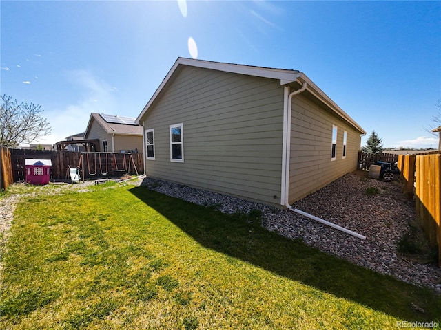 view of side of property featuring a yard and a fenced backyard