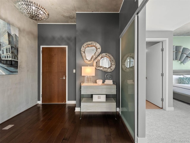 foyer entrance with baseboards, a notable chandelier, and hardwood / wood-style flooring