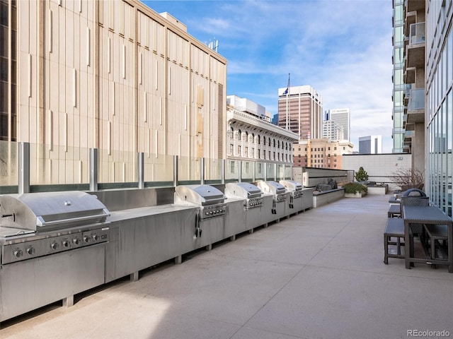view of patio with area for grilling, an outdoor kitchen, and a view of city