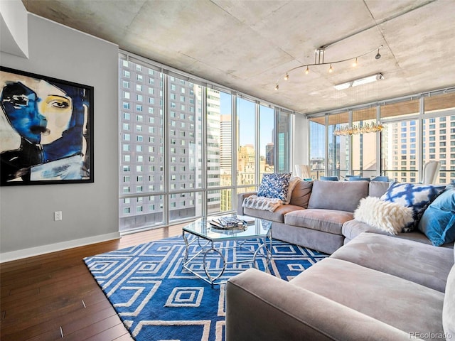 living room featuring expansive windows, hardwood / wood-style flooring, baseboards, and a city view