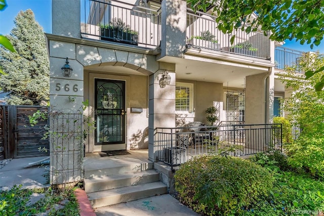 entrance to property with a balcony and stucco siding