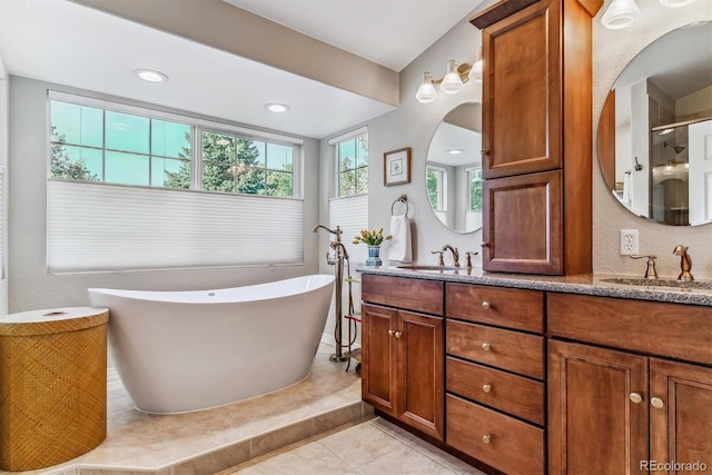 bathroom featuring double vanity, tile patterned flooring, a freestanding bath, and a sink