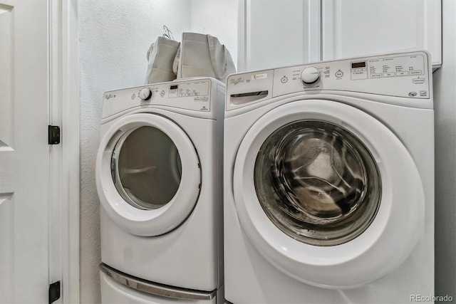 laundry area featuring a textured wall, laundry area, and washer and dryer