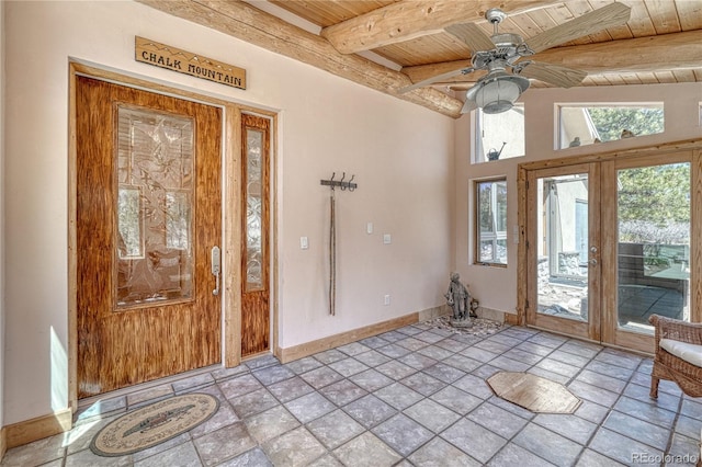foyer with baseboards, beamed ceiling, a ceiling fan, stone finish flooring, and wood ceiling