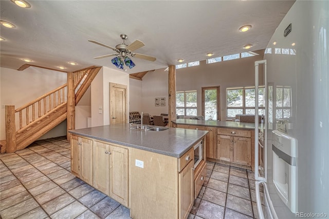 kitchen featuring recessed lighting, white refrigerator with ice dispenser, light brown cabinets, and a sink