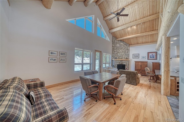 dining room with high vaulted ceiling, hardwood / wood-style floors, beamed ceiling, and a fireplace