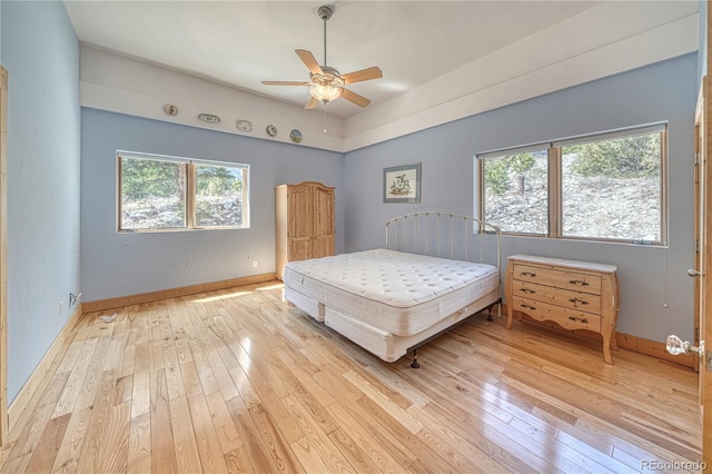bedroom with light wood-type flooring, baseboards, and multiple windows
