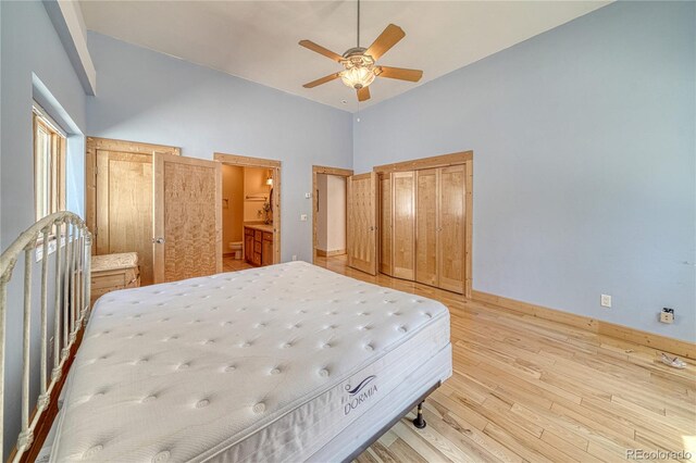 bedroom with baseboards, light wood-style floors, a high ceiling, ceiling fan, and connected bathroom