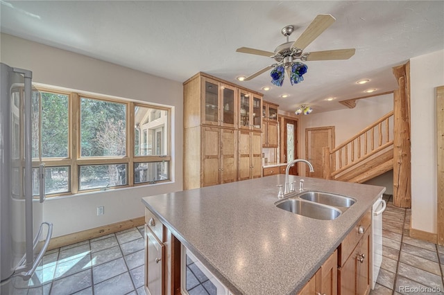 kitchen featuring a ceiling fan, a sink, a center island with sink, baseboards, and recessed lighting