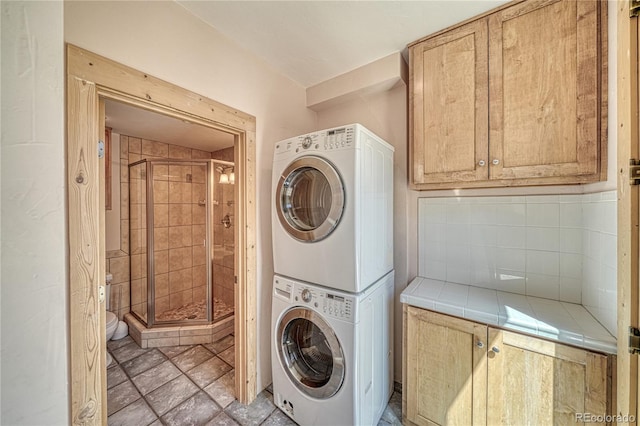 laundry room featuring stacked washer / drying machine and laundry area