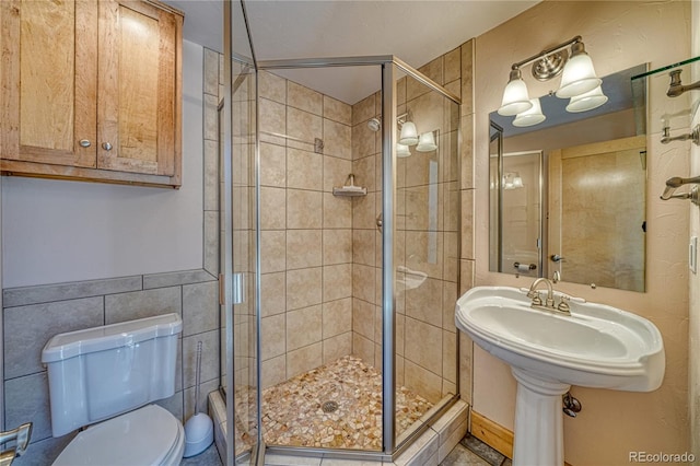 full bathroom with tile walls, toilet, and a stall shower