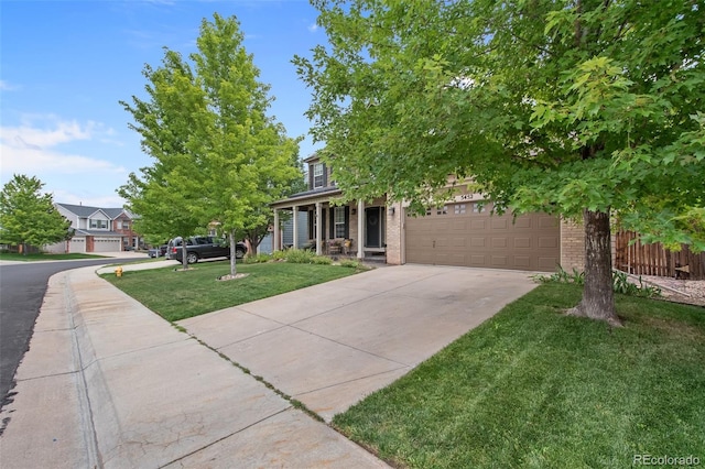 obstructed view of property featuring a front yard, covered porch, and a garage