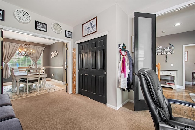 entryway with carpet floors and an inviting chandelier