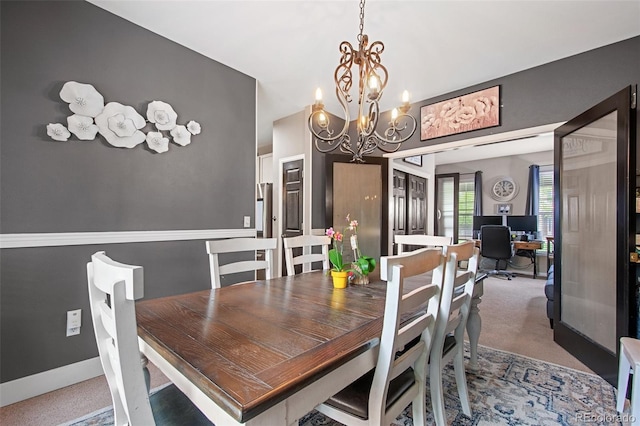 dining area with carpet and a notable chandelier