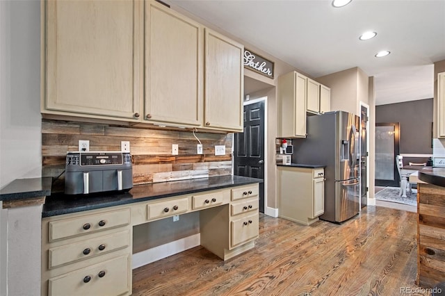 kitchen featuring decorative backsplash, stainless steel fridge, hardwood / wood-style flooring, and cream cabinets