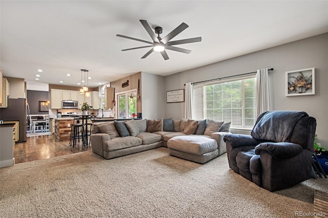 living room with ceiling fan, carpet floors, and sink