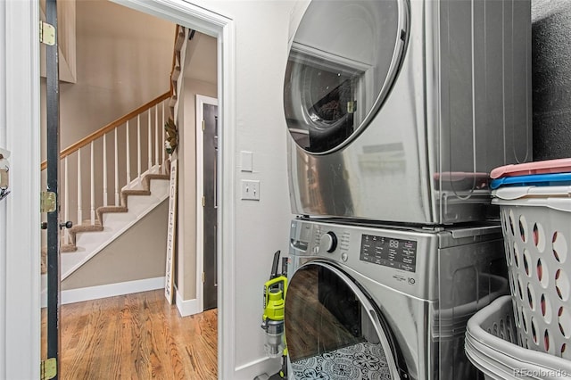 clothes washing area with stacked washer / drying machine and hardwood / wood-style floors