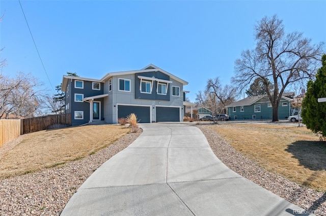 view of front facade featuring an attached garage, driveway, and fence