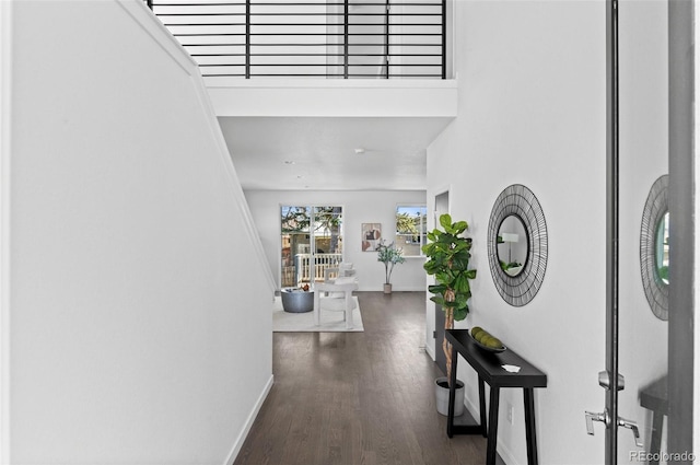 hall with baseboards and wood finished floors