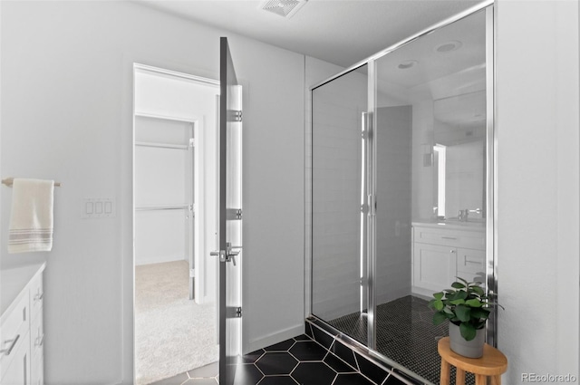 bathroom featuring visible vents, a stall shower, and vanity