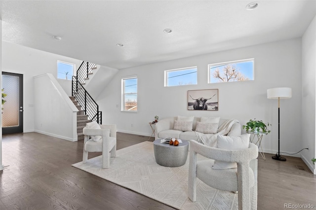 living room with recessed lighting, stairs, baseboards, and wood finished floors