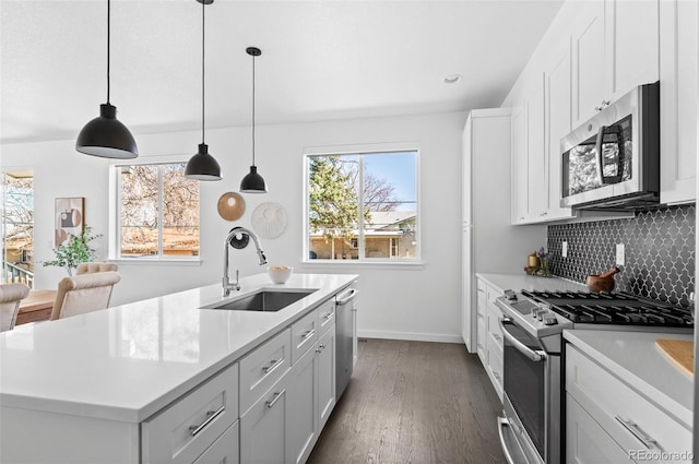 kitchen with a sink, stainless steel appliances, tasteful backsplash, and light countertops