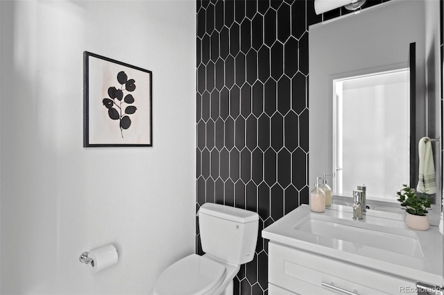 bathroom with vanity, tile walls, and toilet