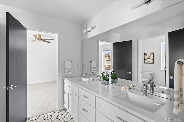 full bathroom with toilet, a ceiling fan, and a sink