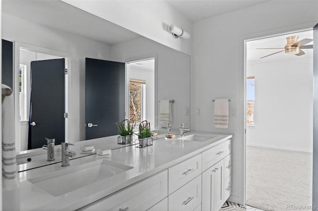 bathroom featuring double vanity, baseboards, and a sink